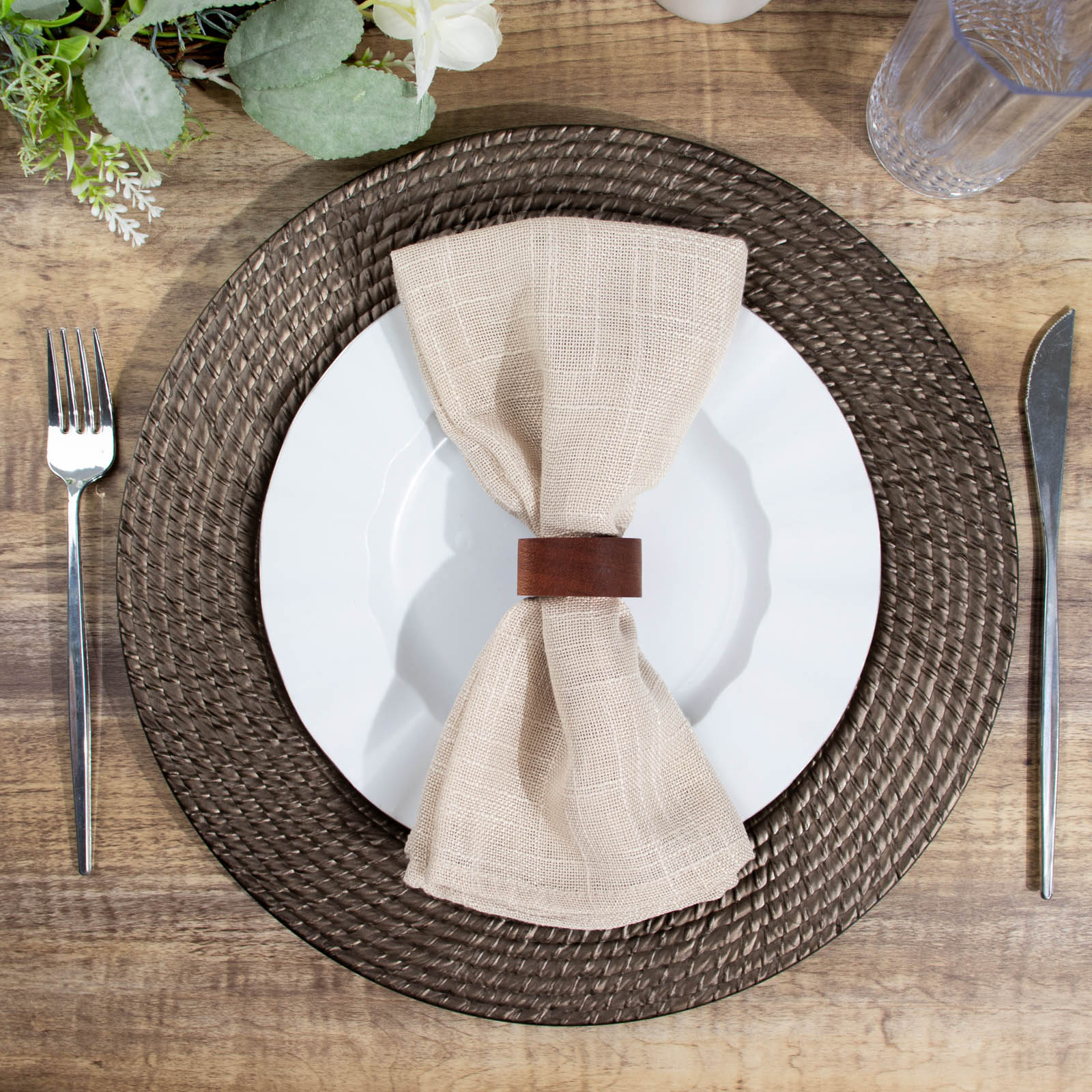 Natural brown charger plate with rattan-like design on a rustic table setting.