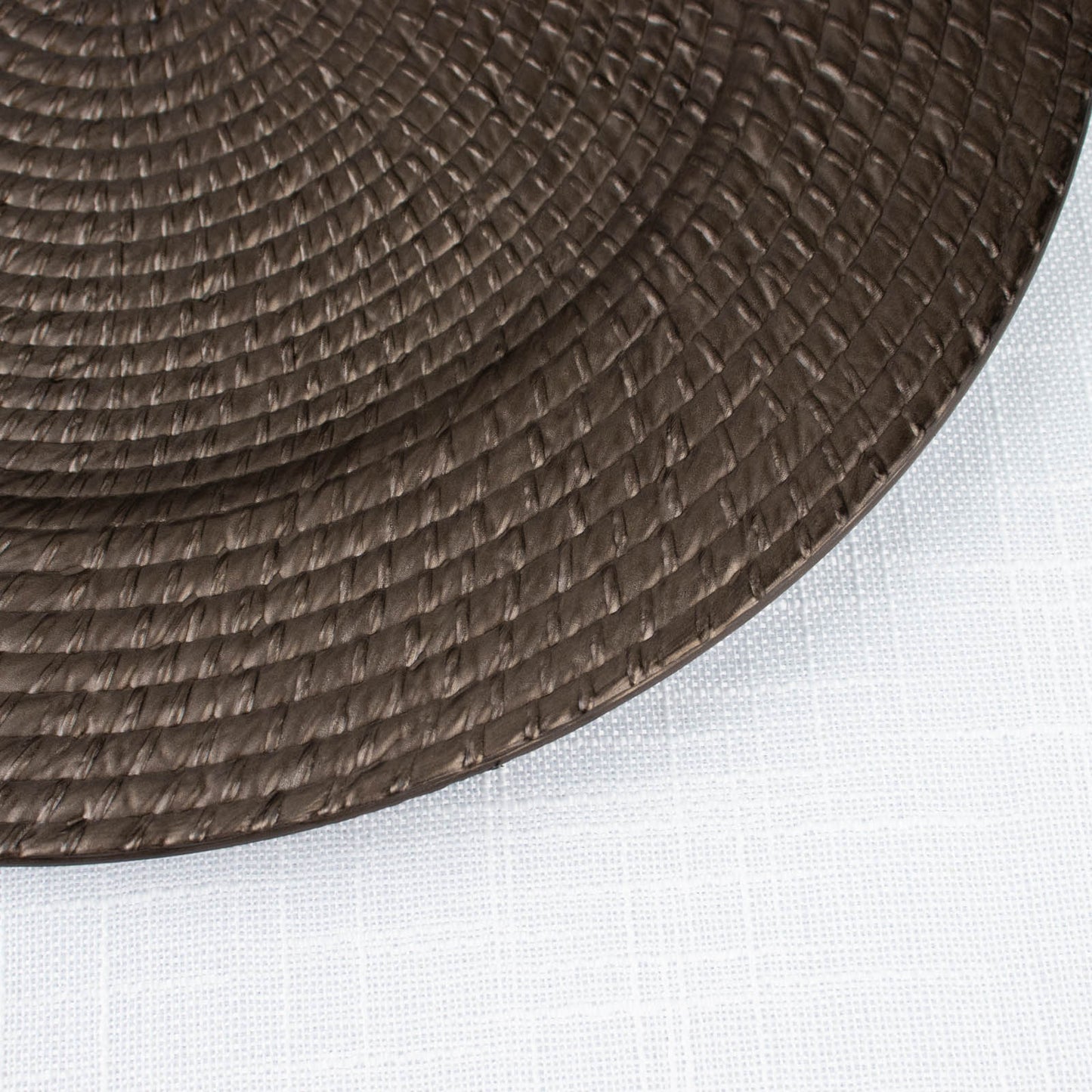 Natural brown acrylic round charger plate with rattan-like design.