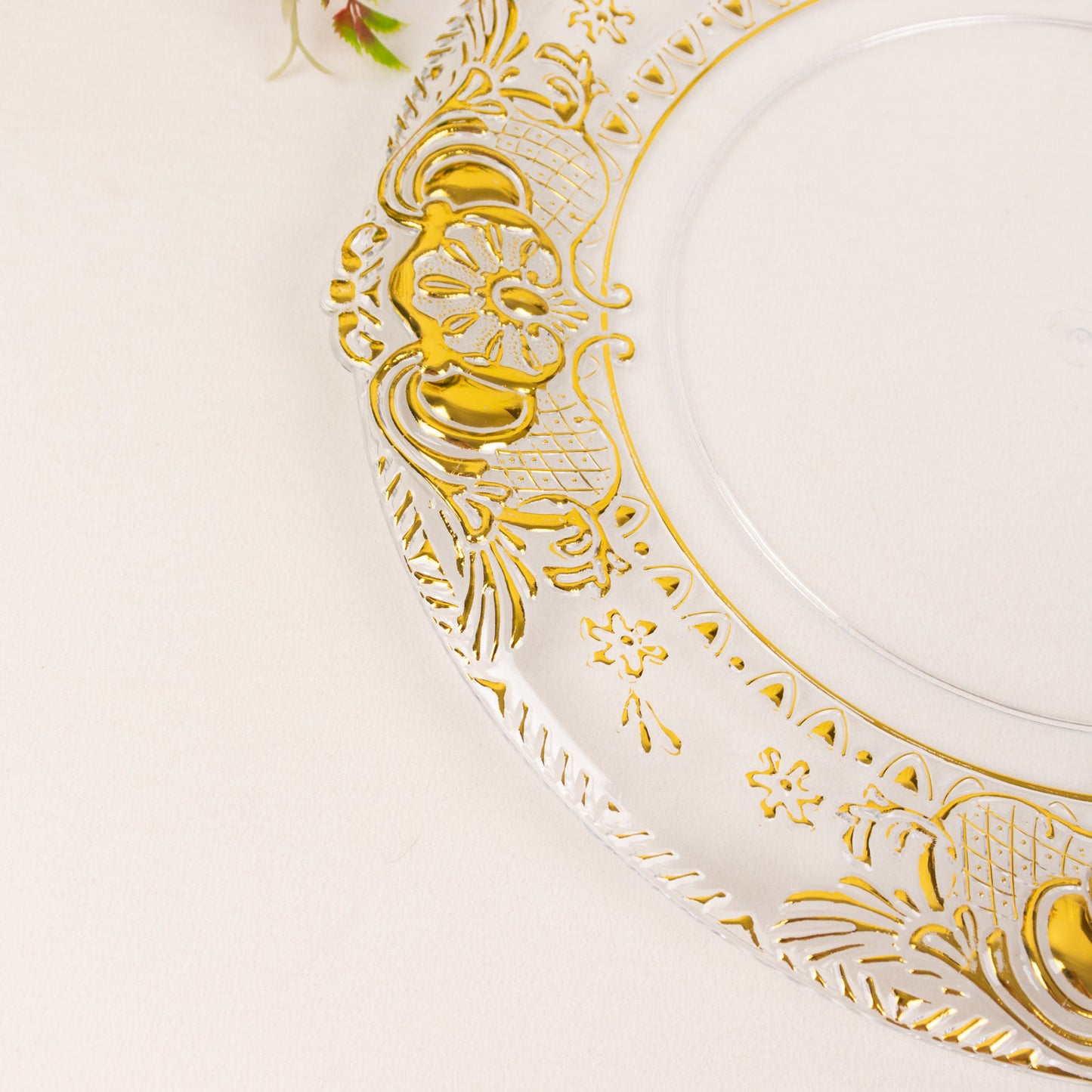 Clear decorative charger plate with gold embossed rim, 13" round.