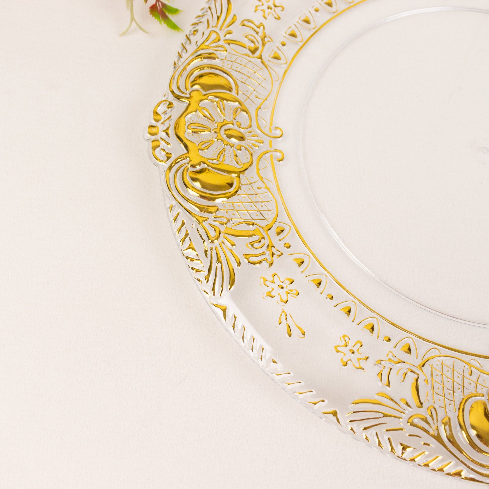 Clear decorative charger plate with gold embossed rim, 13" round.