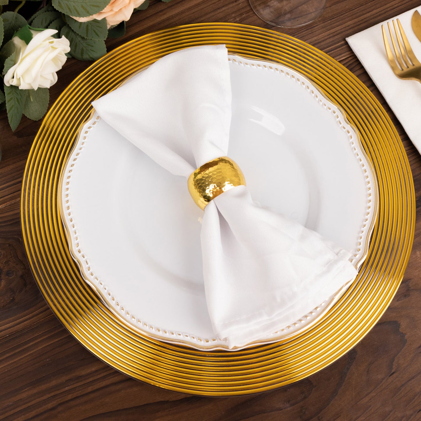 Clear gold lined rim disposable wedding charger plate on a wooden table.
