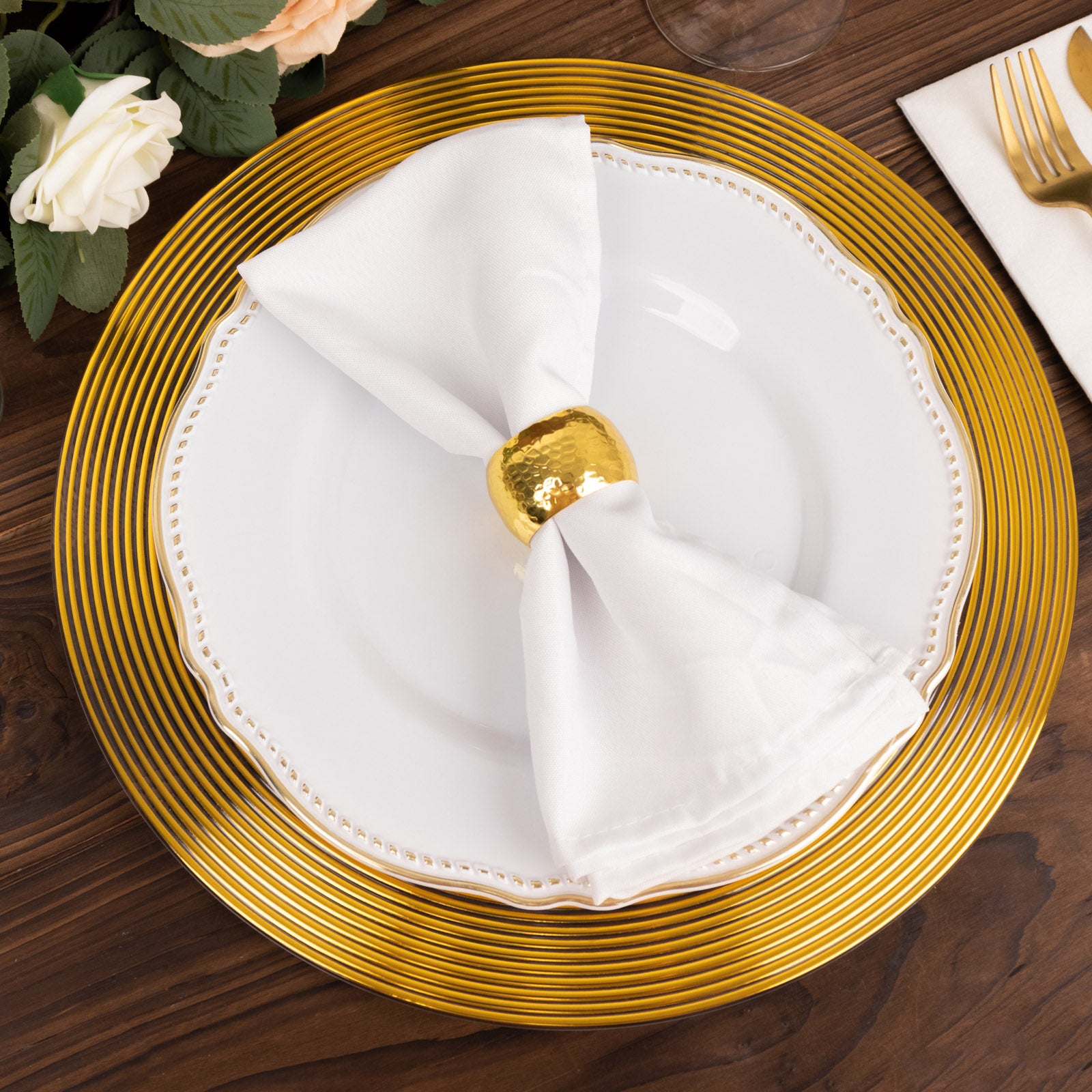 Clear gold lined rim disposable wedding charger plate on a wooden table.