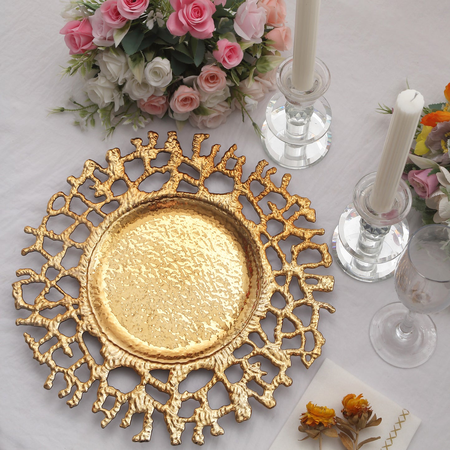 Gold decorative acrylic charger plate with a hollow lace design.
