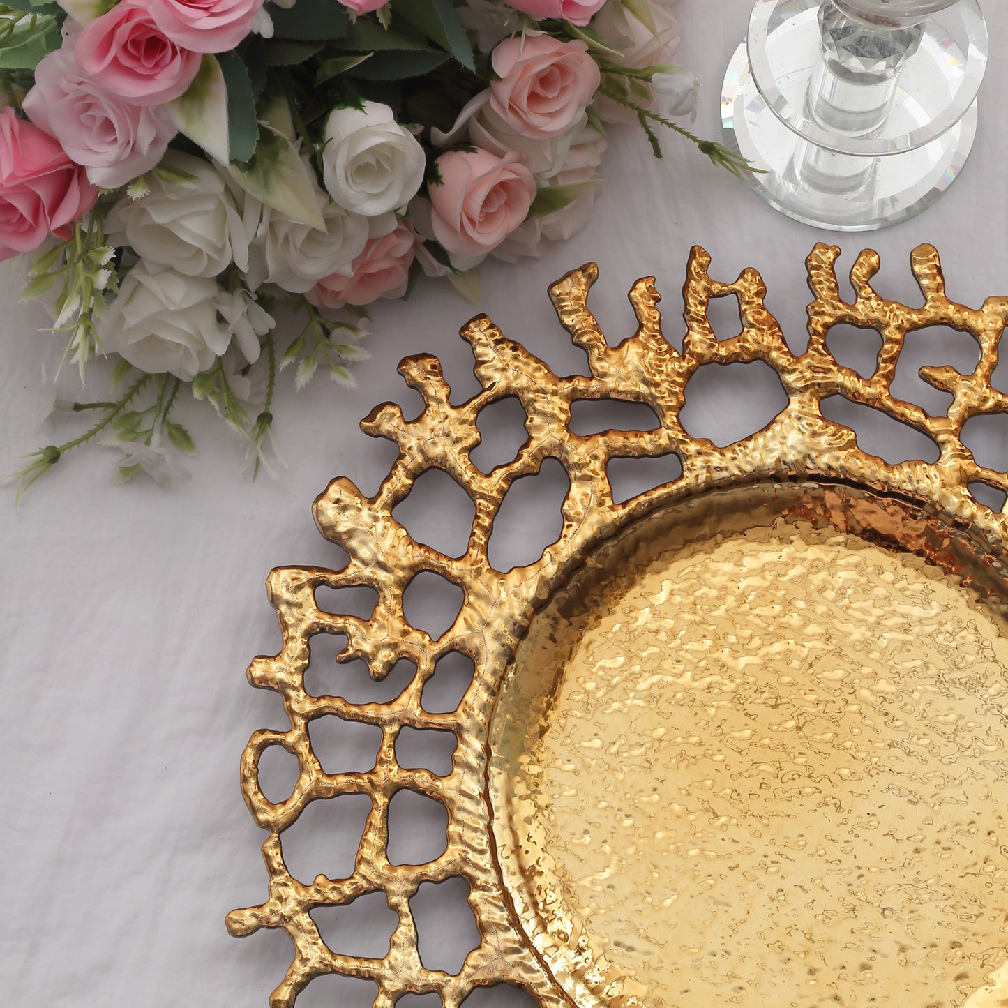 Gold acrylic charger plate with a decorative lace design.