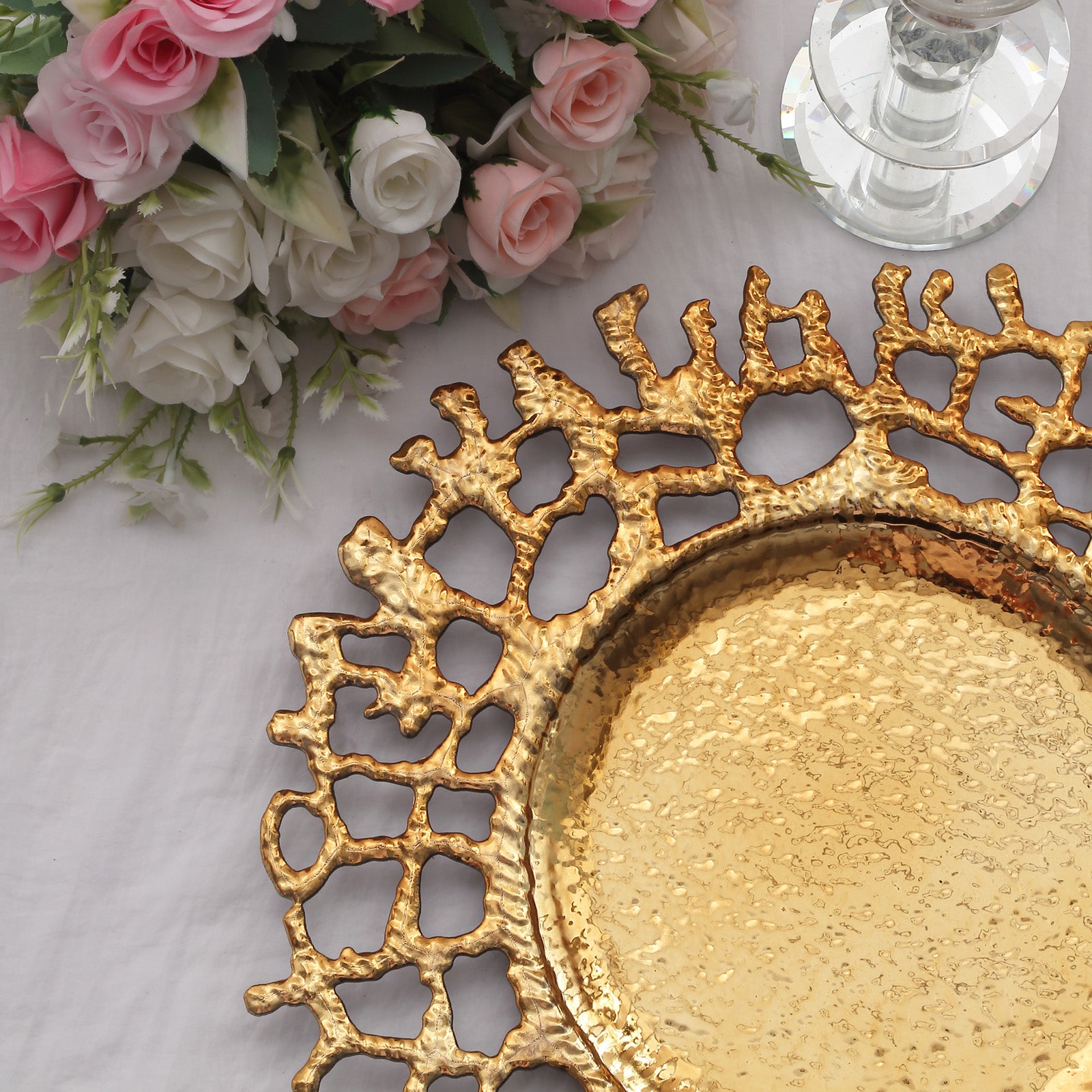 Gold acrylic charger plate with a decorative lace design.