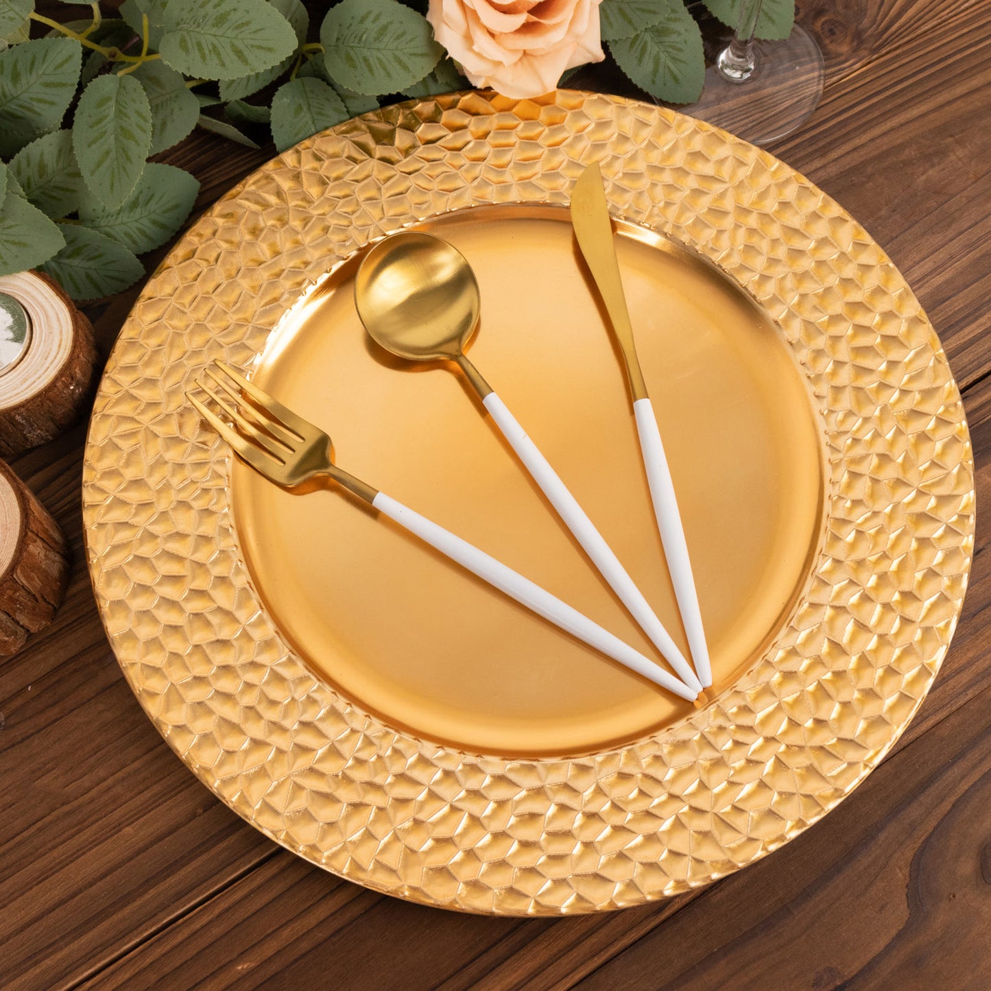 Metallic gold acrylic dinner serving plate with hammered rim and utensils.