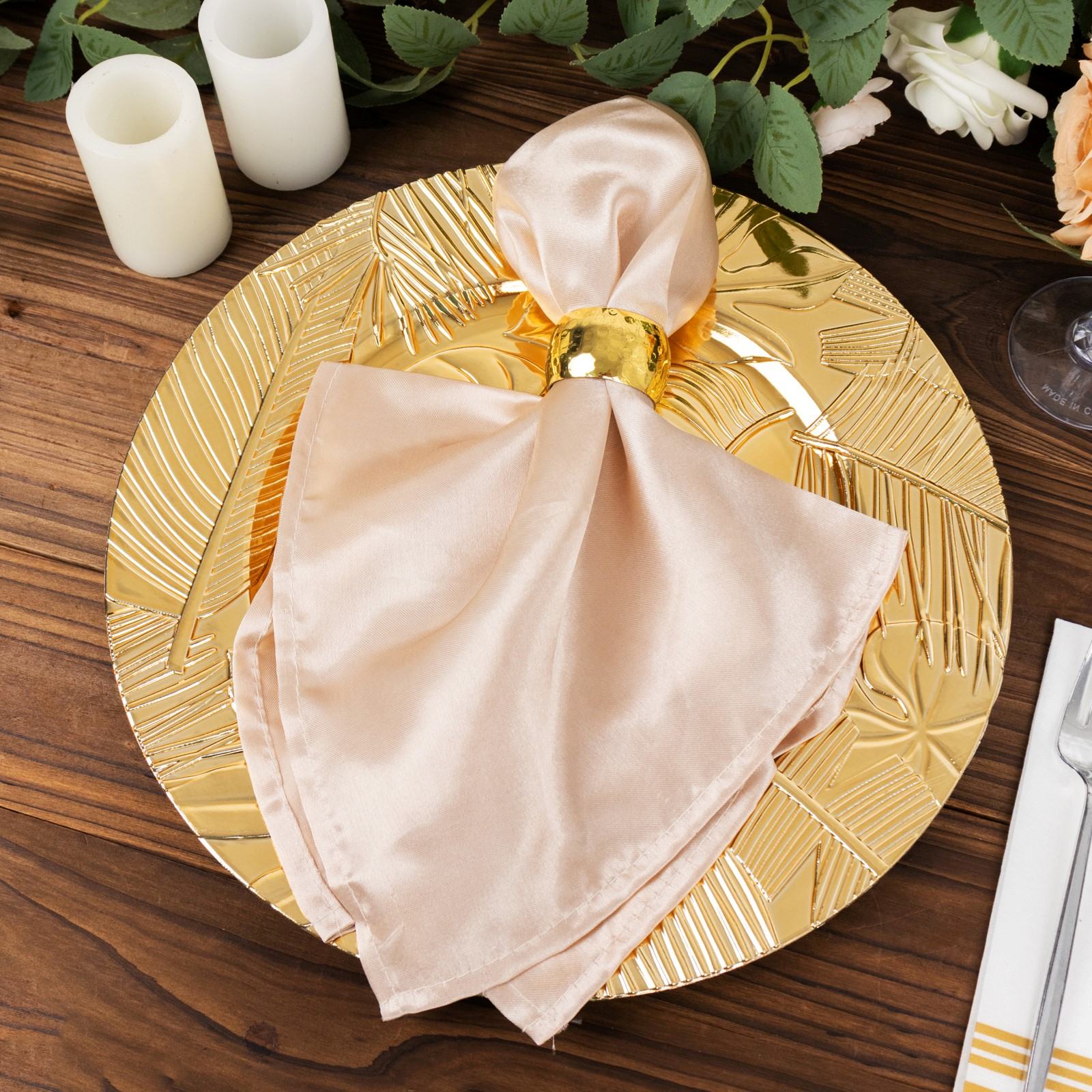 Metallic gold acrylic charger plate with embossed tropical leaves.
