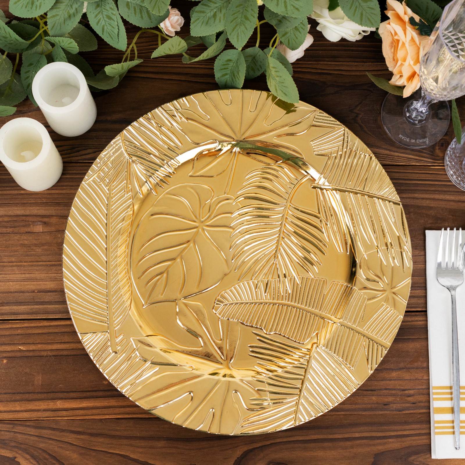 Metallic gold embossed charger plate with tropical leaves design.