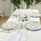 Antique white round acrylic charger plates with floral embossed design on a table setting.