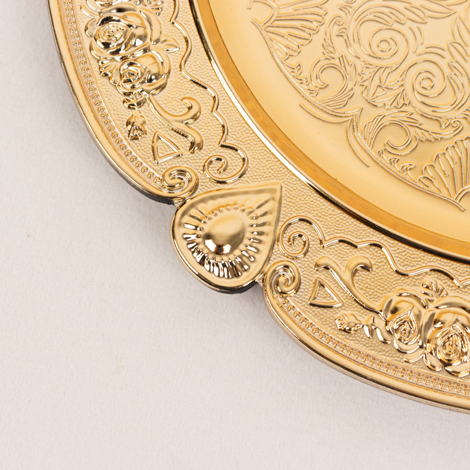 Gold round acrylic charger plate with floral embossed scalloped rim.