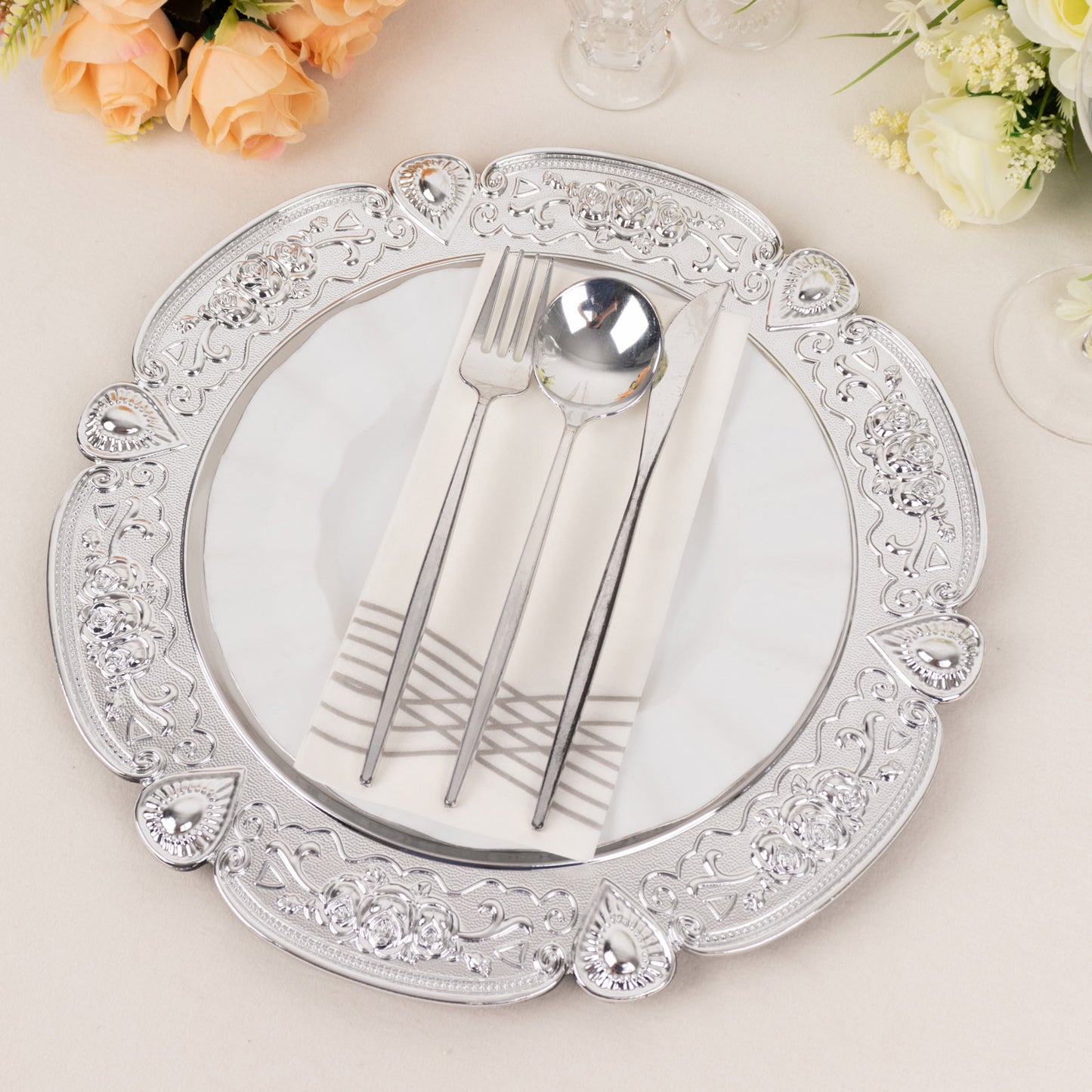 Silver round acrylic charger plate with floral embossed scalloped rim.