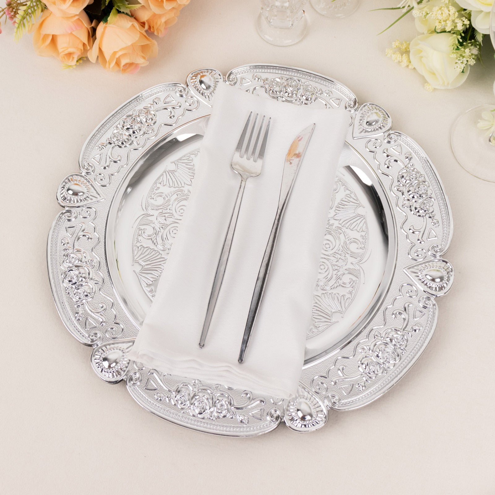 Silver round acrylic charger plate with floral embossed scalloped rim.