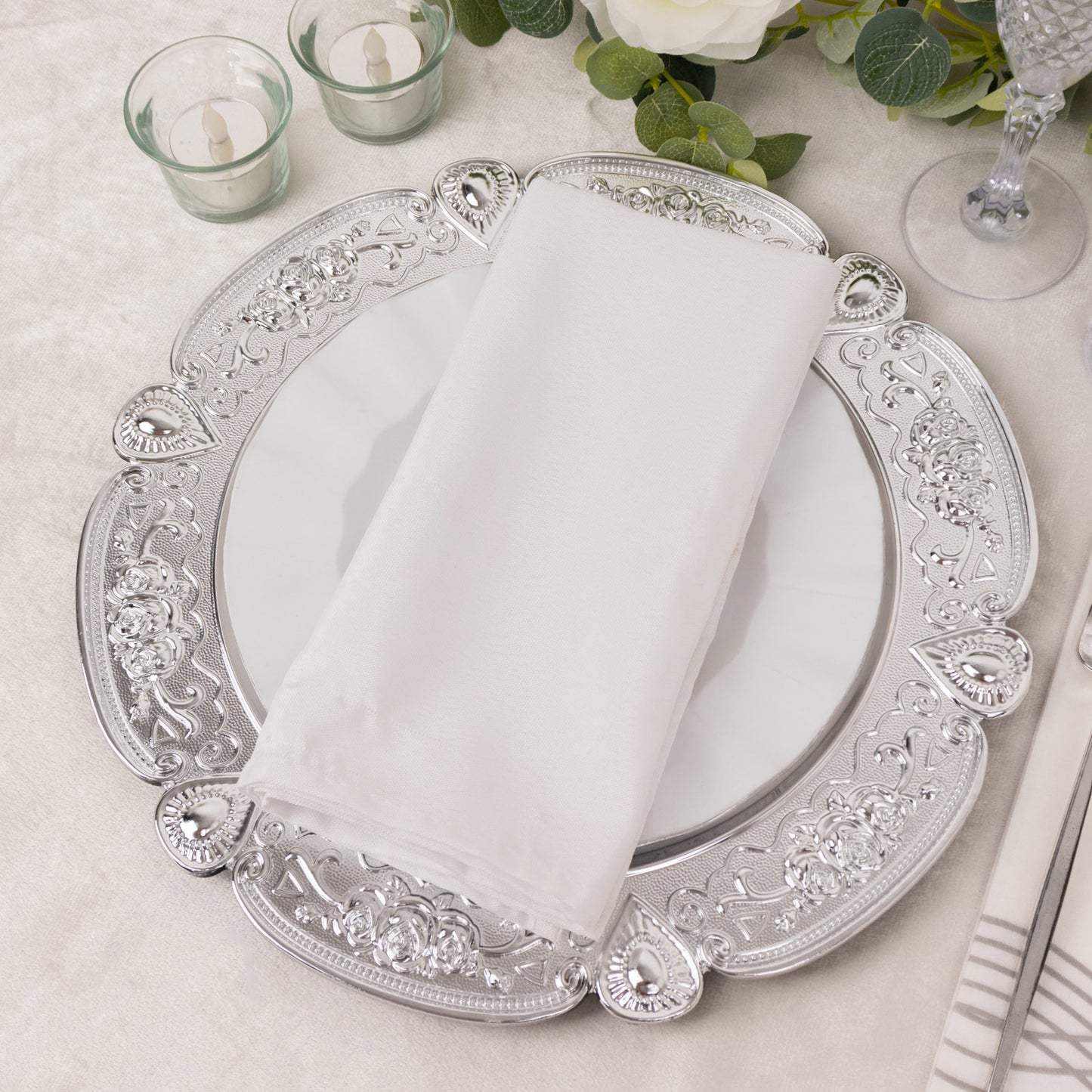 Silver round acrylic charger plate with floral embossed scalloped rim.