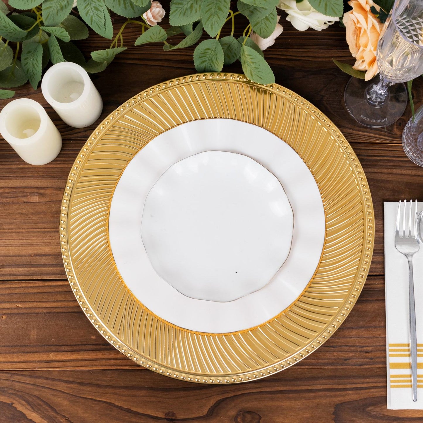 Metallic gold swirl charger plate with beaded rim on a wooden table.