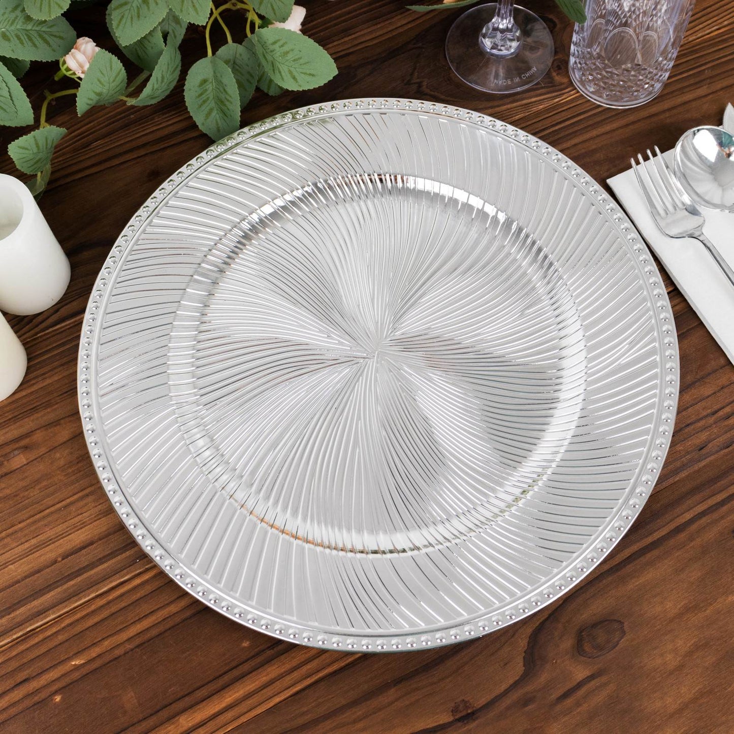 Metallic silver swirl pattern round acrylic charger plate with beaded rim.