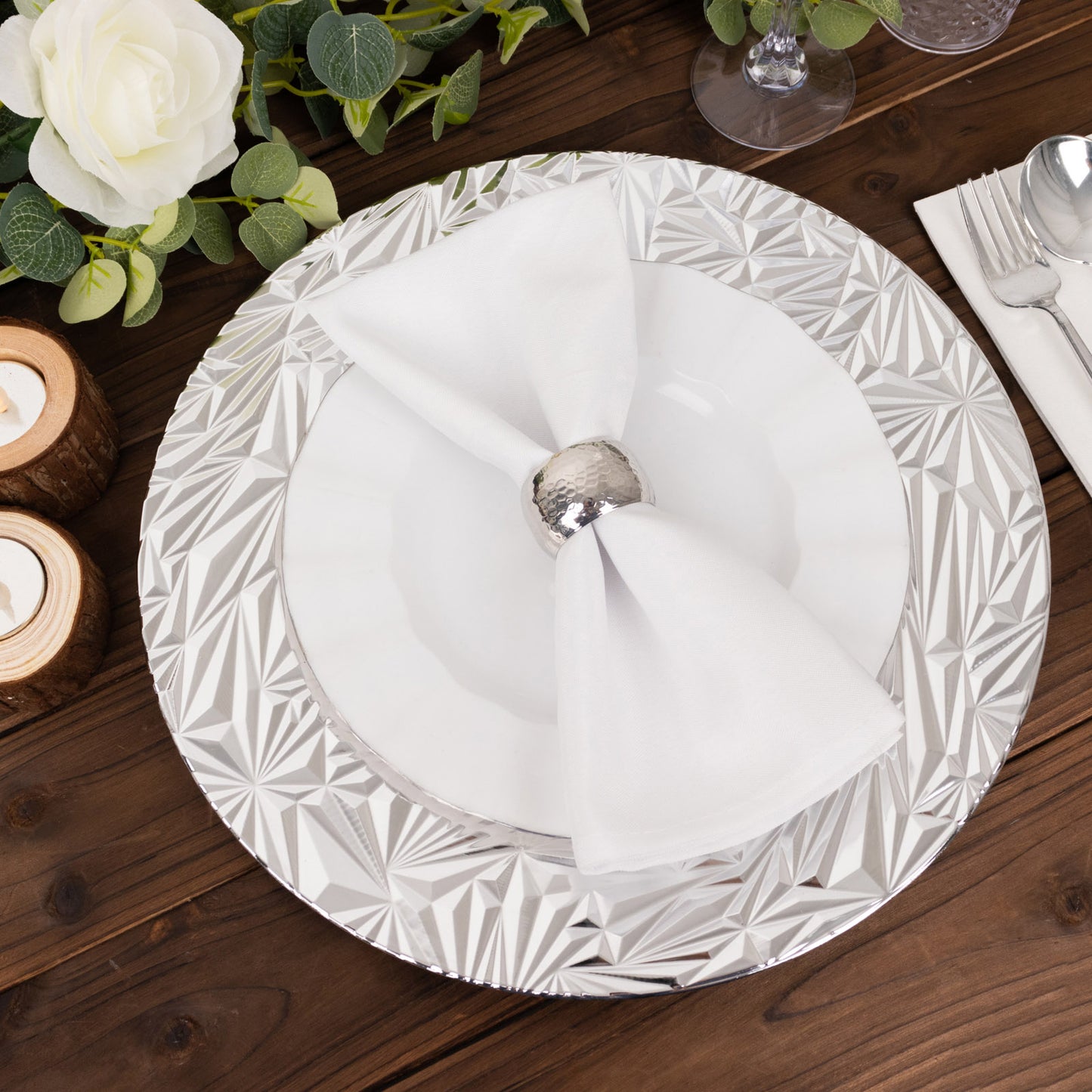 Metallic silver rock cut acrylic charger plate on a wooden table setting.