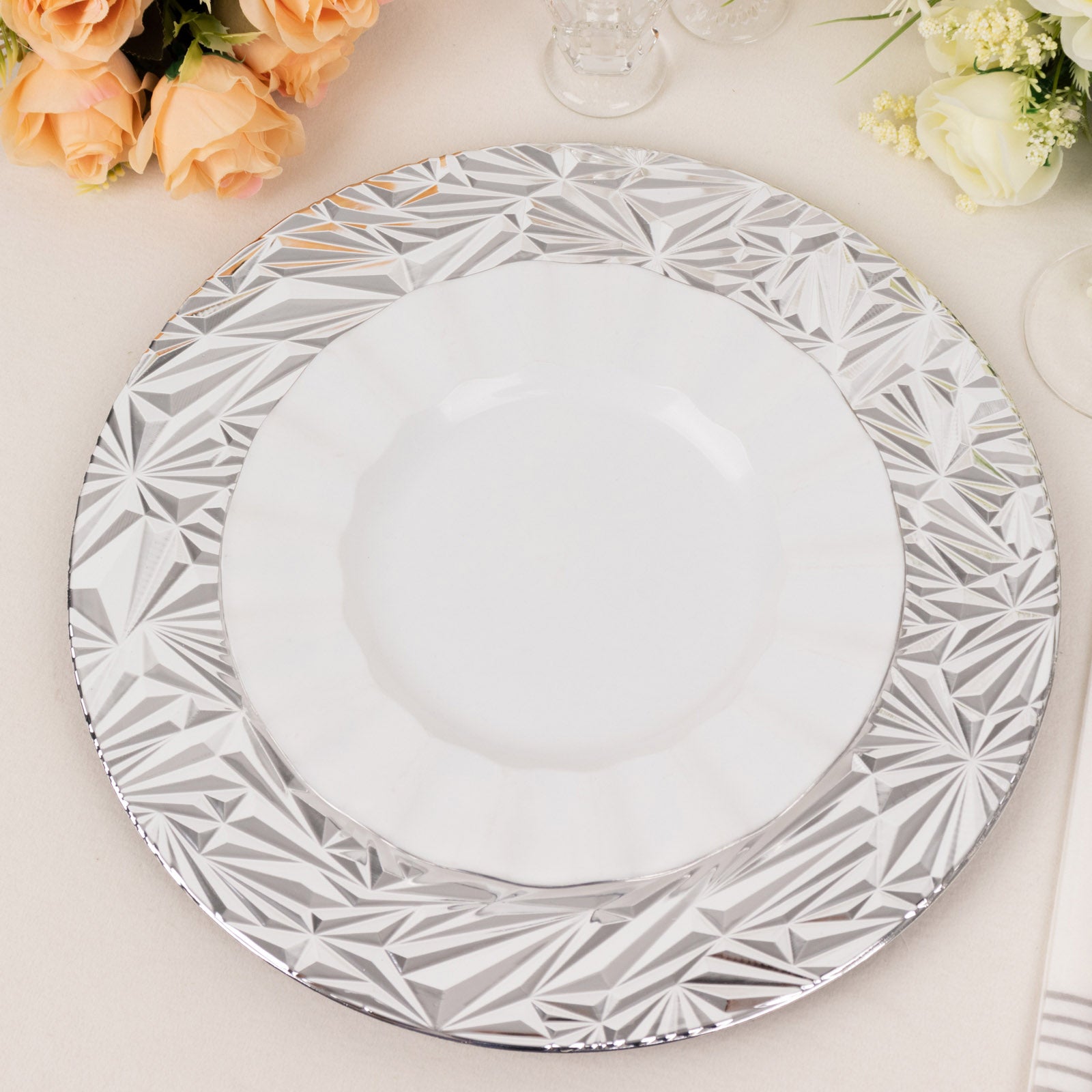 Metallic silver rock cut acrylic charger plate on a table setting.