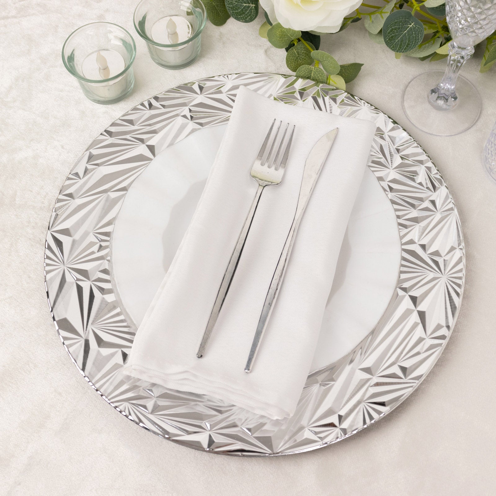 Metallic silver rock cut acrylic charger plate on a dining table setting.