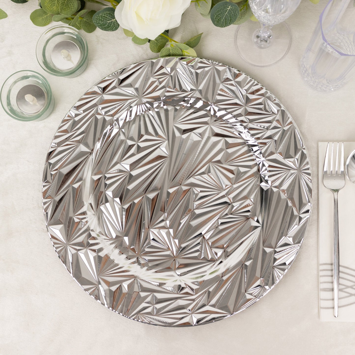 Metallic silver rock cut acrylic charger plate on a table setting.