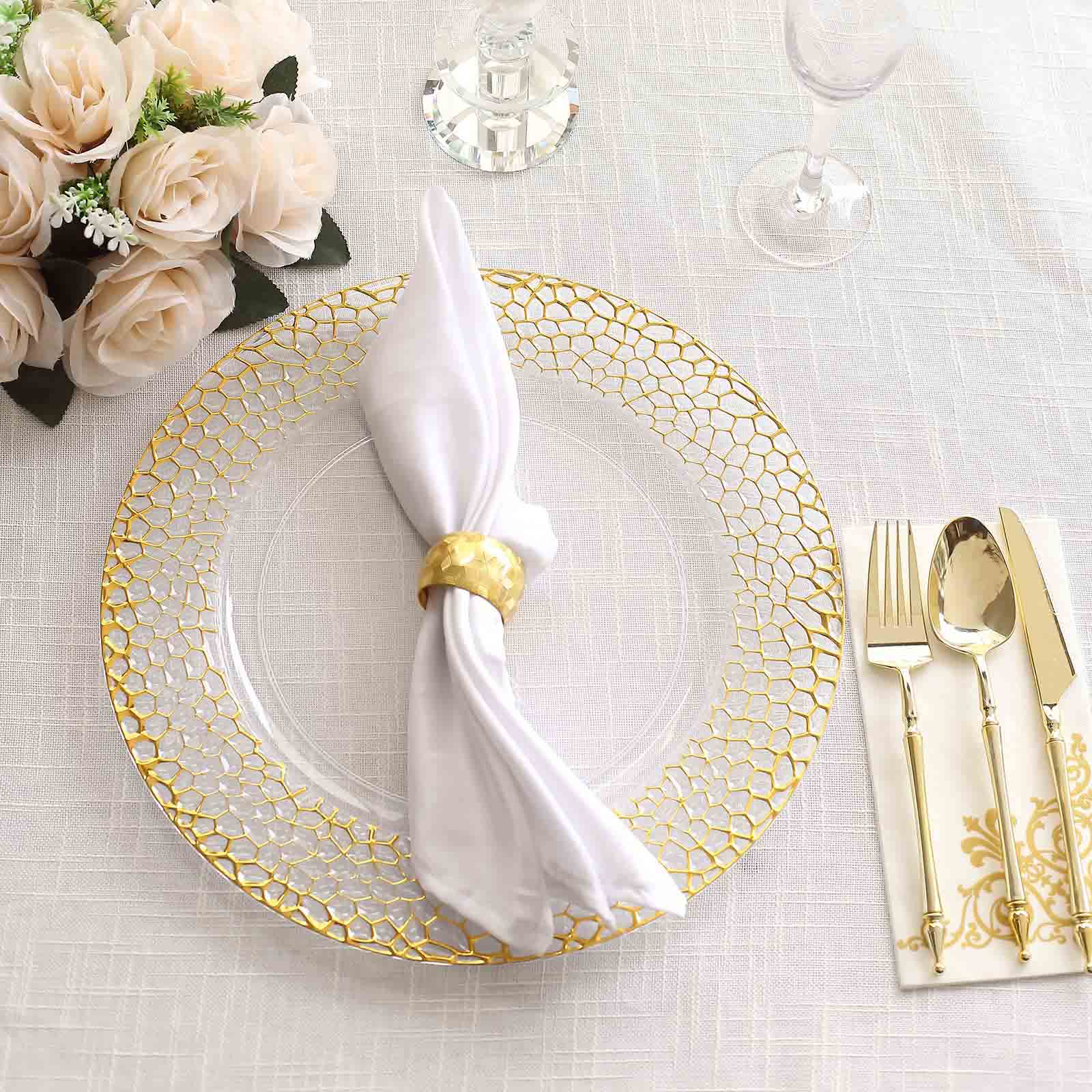 Clear acrylic charger plate with gold hammered rim on a table setting.