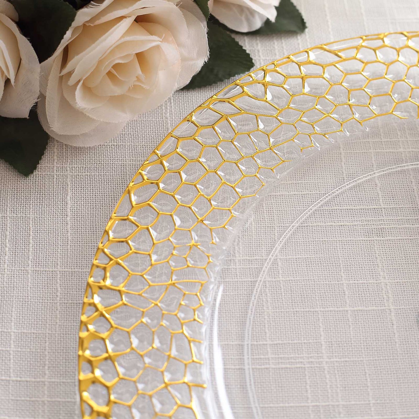 Clear acrylic round charger plate with a gold hammered rim.