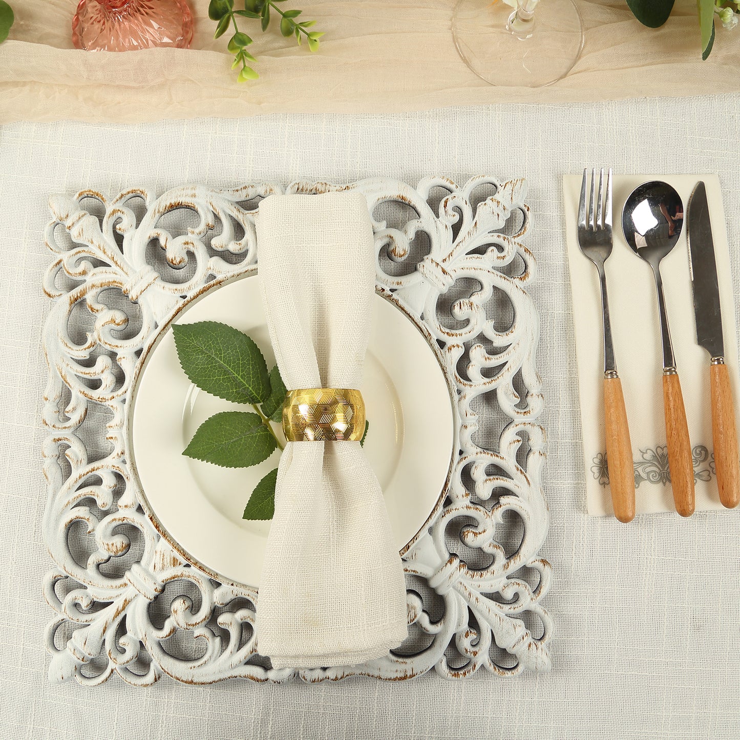 Antique white square acrylic charger plate with lace border on a dining table.