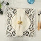 Antique white square acrylic charger plate with lace border on a dining table.