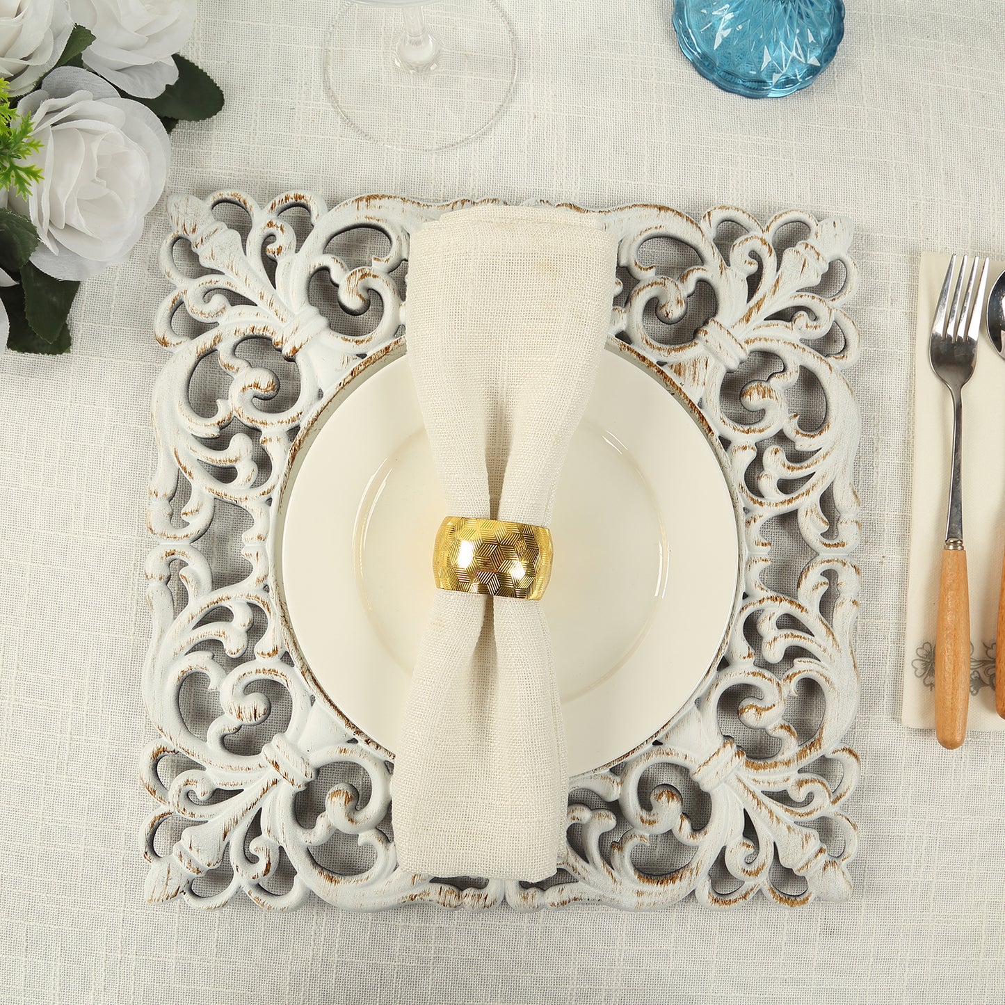 Antique white square acrylic charger plate with lace border on a dining table.