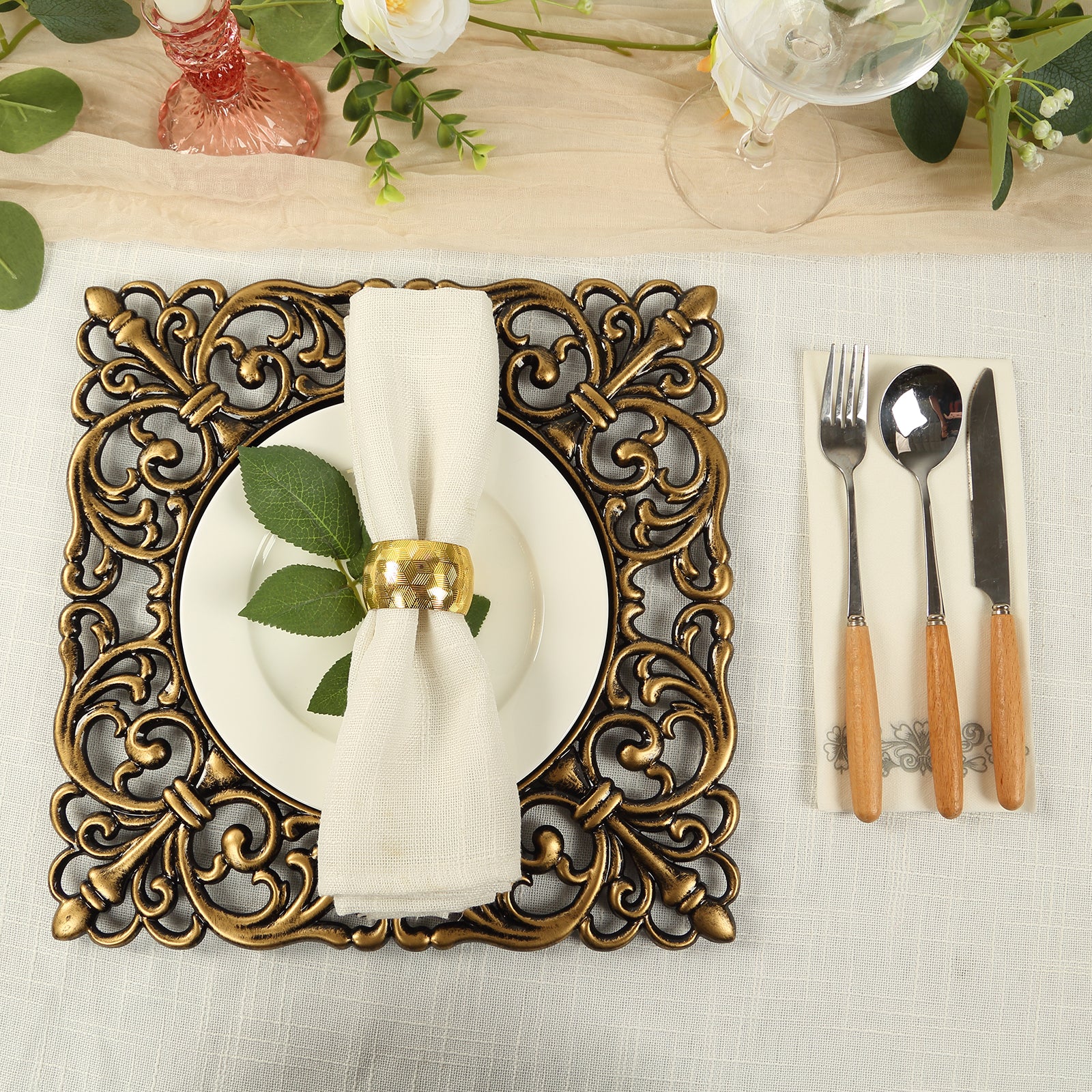 Black square acrylic charger plate with antique gold lace border on a table setting.