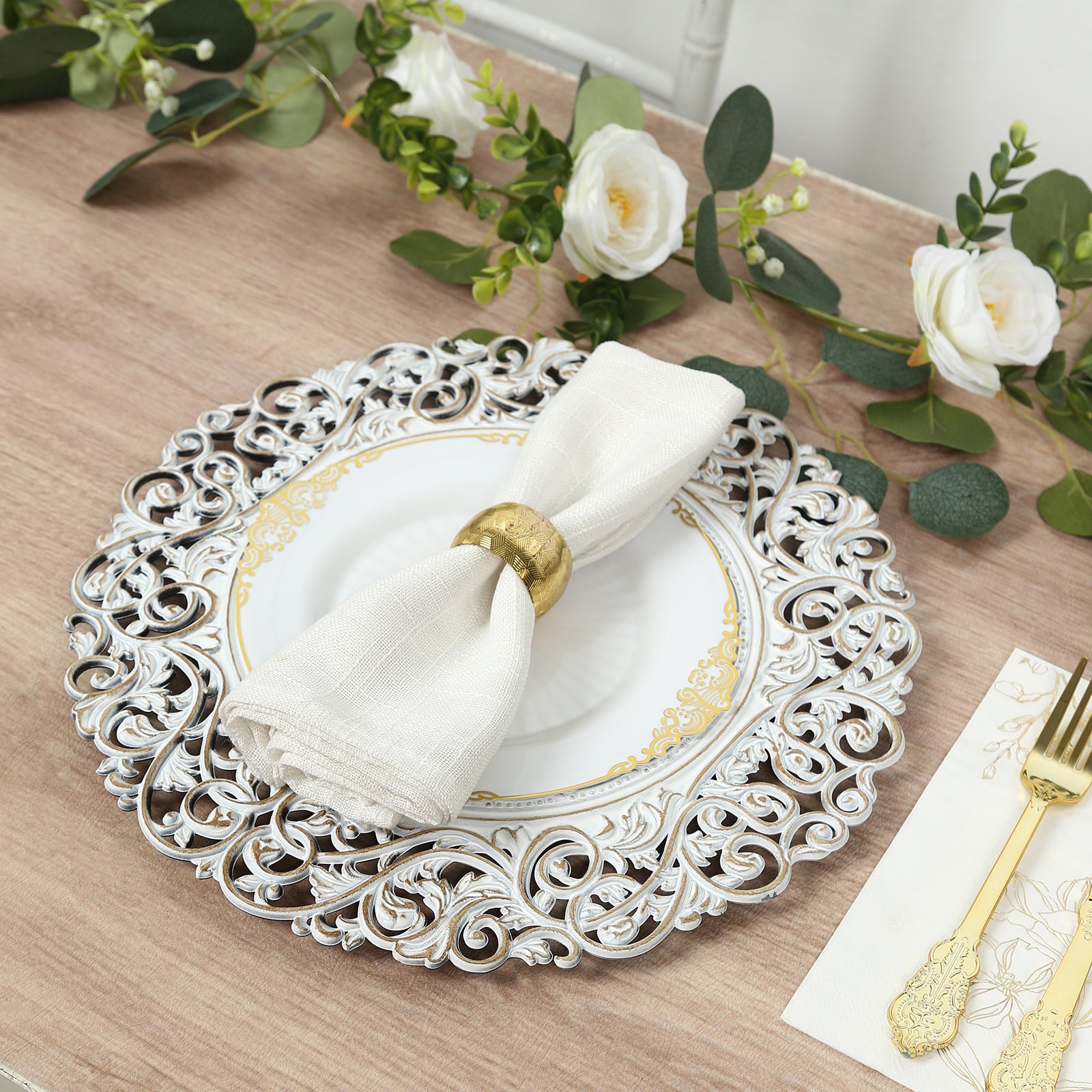Antique white round charger plate with vintage floral design on a table setting.