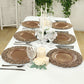 Brown charger plates with vintage floral rim on a decorated table setting.