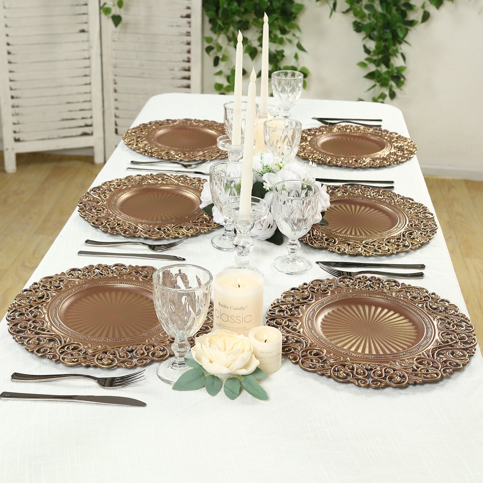 Brown charger plates with vintage floral rim on a decorated table setting.