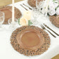 Brown charger plate with vintage floral design on an elegant table setting.