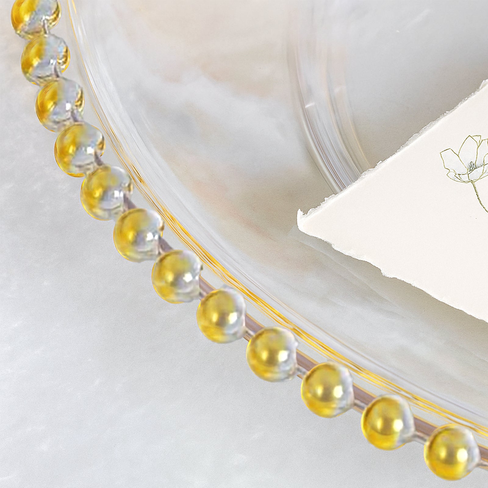 Clear gold acrylic charger plate with beaded rim.