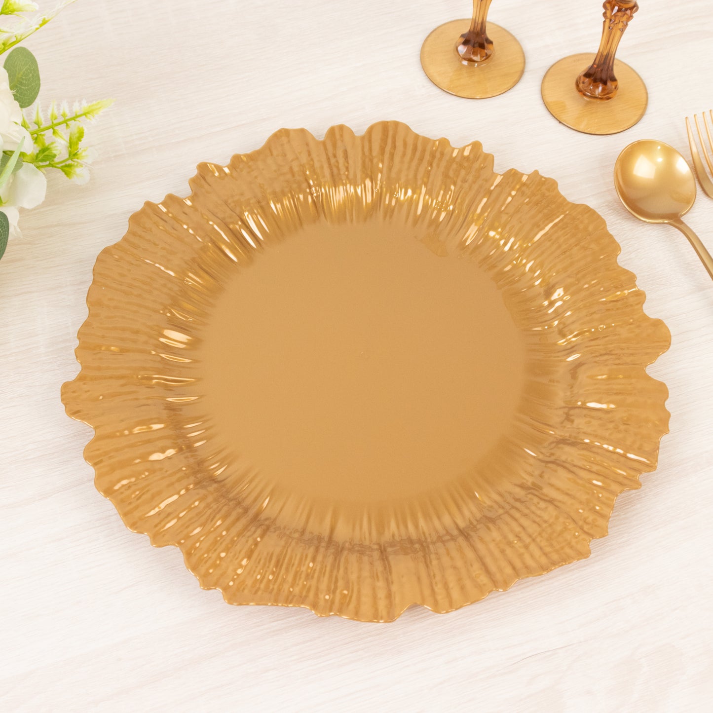 Gold charger plate with a decorative edge on a light surface.