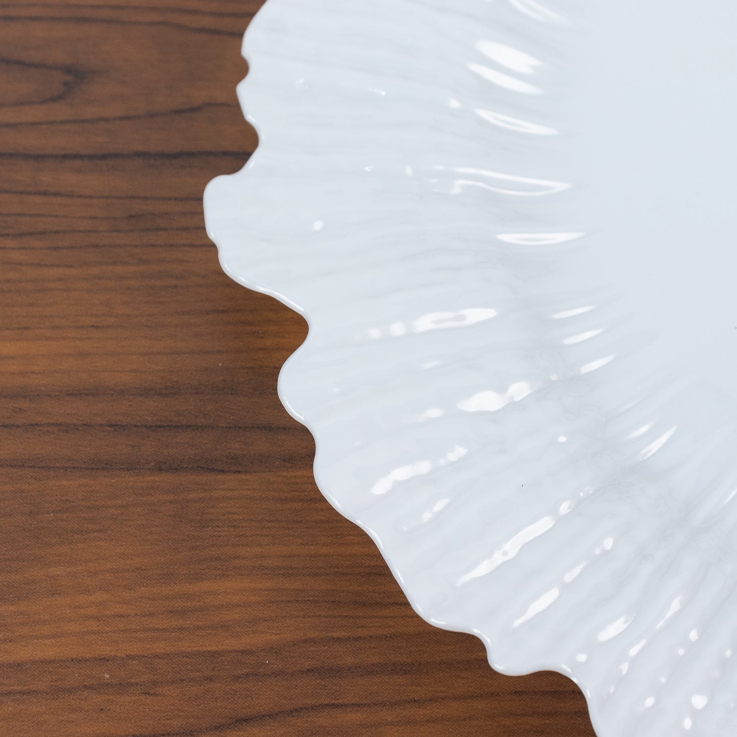 Pearl white charger plate on a wooden surface. Ideal for events and catering.