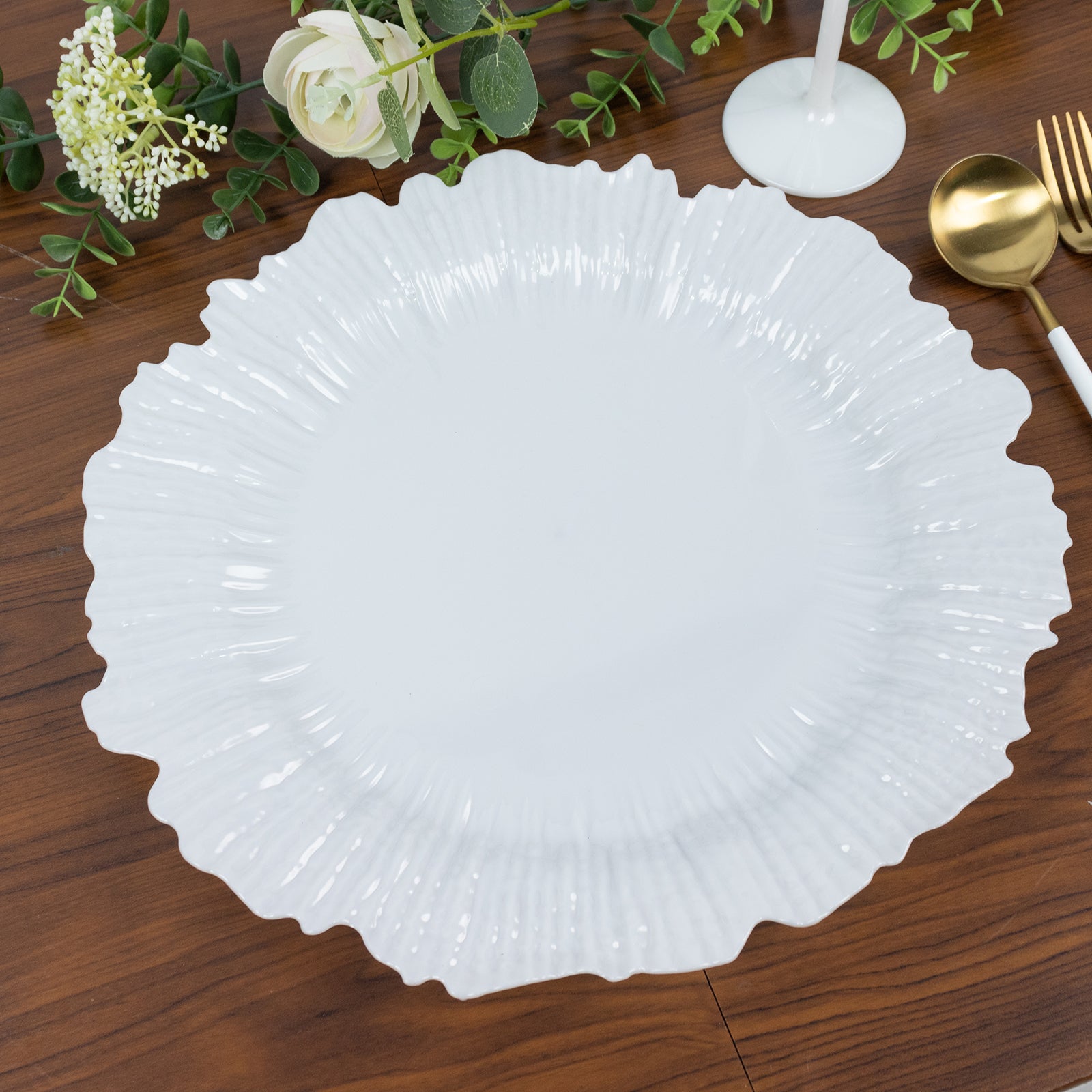 Pearl white charger plate on a wooden table with decorative elements.