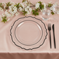 Clear charger plate with black scalloped rim on a pink tablecloth.