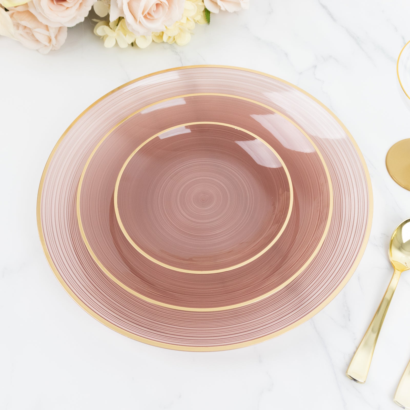Transparent dusty rose charger plate with gold rim, stylish tableware.