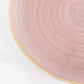 Transparent dusty rose swirl charger plate with gold rim.