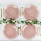 Transparent dusty rose swirl charger plates with gold rim on a marble table setting.