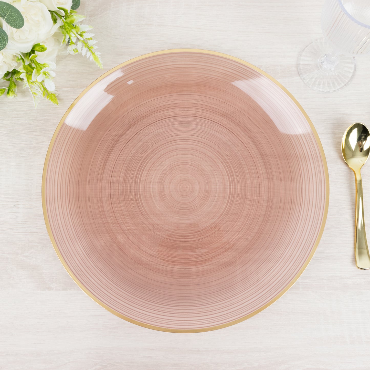 Transparent dusty rose swirl charger plate with gold rim.