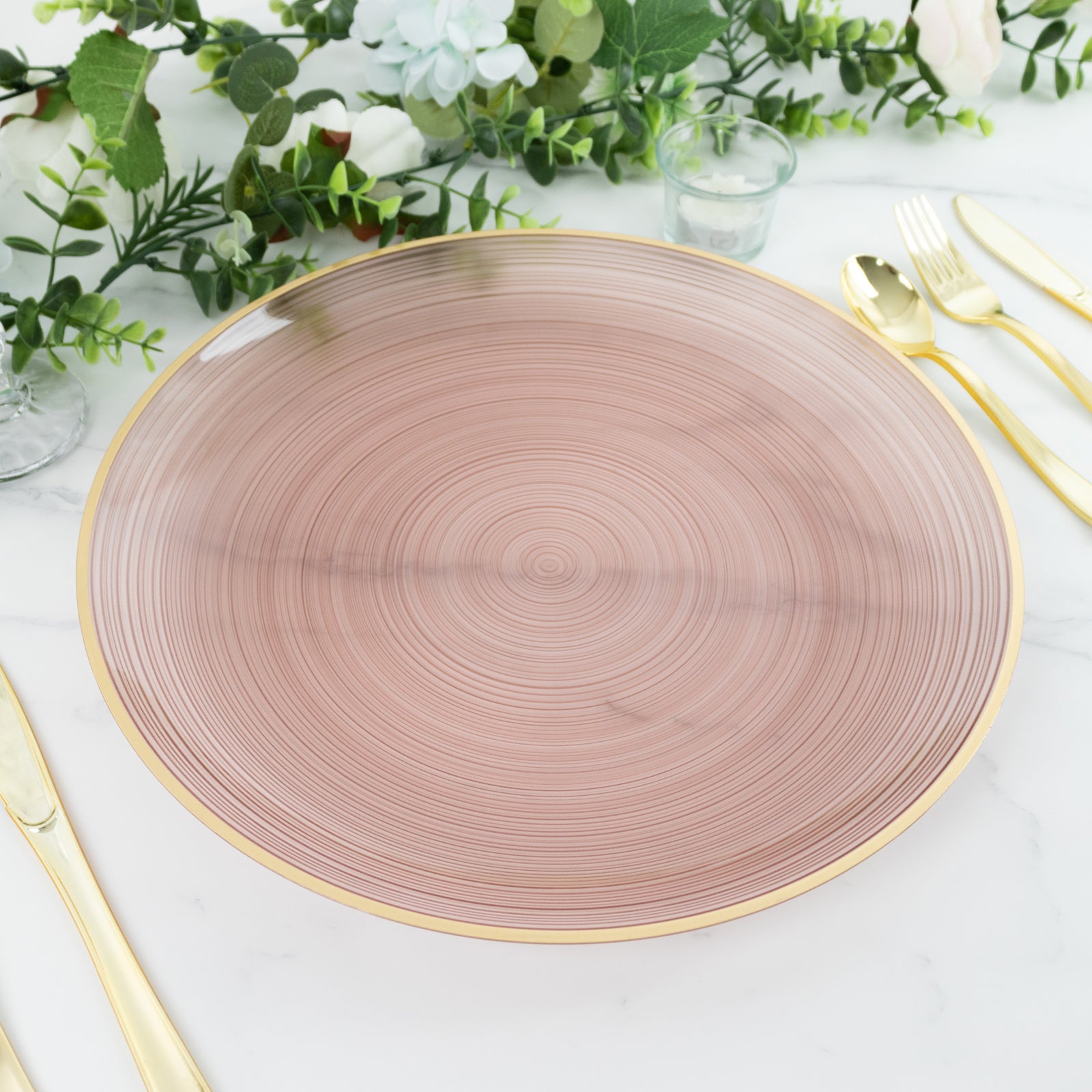 Transparent dusty rose swirl charger plate with gold rim.