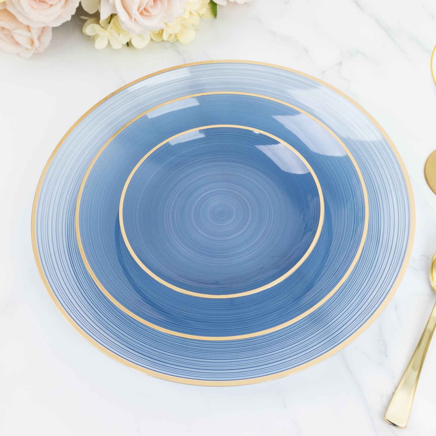 Transparent dusty blue swirl charger plate with gold rim.