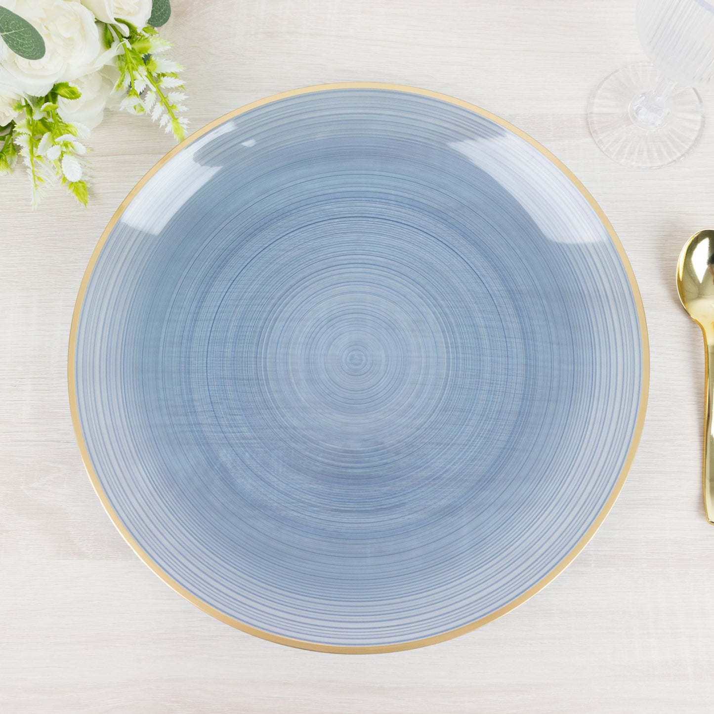 Transparent dusty blue swirl charger plate with gold rim.