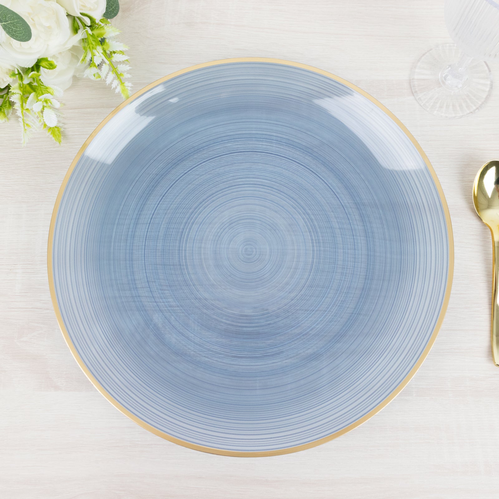 Transparent dusty blue swirl charger plate with gold rim.