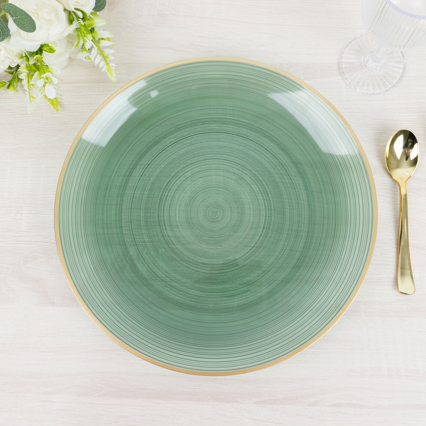 Transparent dusty sage green swirl charger plate with gold rim.