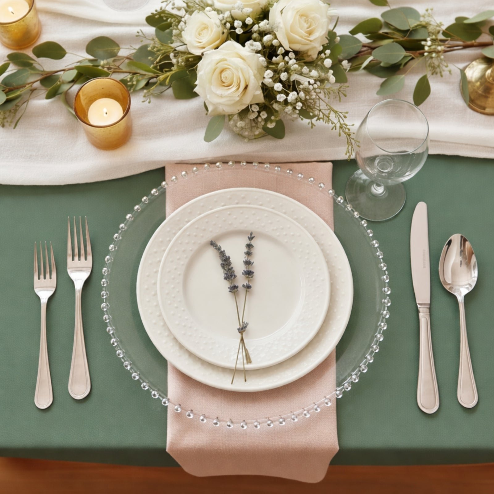 Clear beaded rim charger plates on a styled dinner table setting.