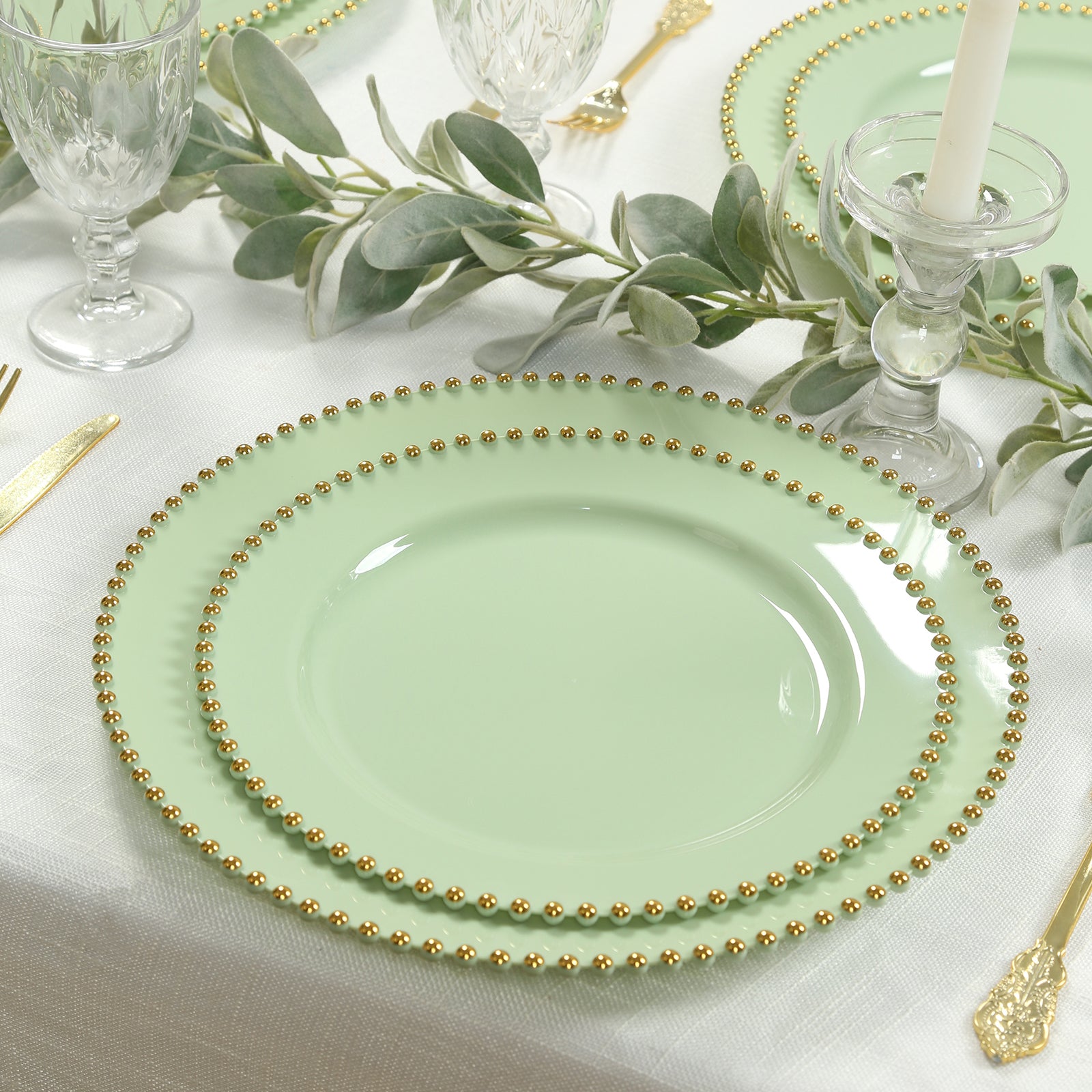 Sage green round plastic charger plates with gold beaded rim, stylish dinner party serving.