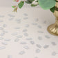 Silver glitter crown confetti scattered on a table for a princess theme party.